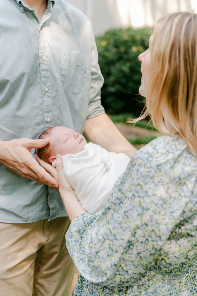 Mom holding baby outdoors in backyard at newborn photoshoot in Roswell, GA 